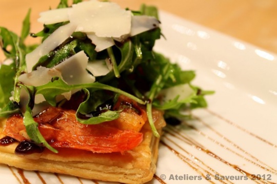 Tarte fine aux zucchini et prosciutto, oignons caramélisés, copeaux de Parmesan et feuilles de roquette |