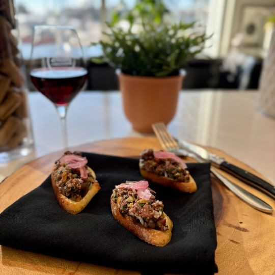 Duck breast tartare with roasted hazelnuts, Kalamata olives, and marinated red onions |